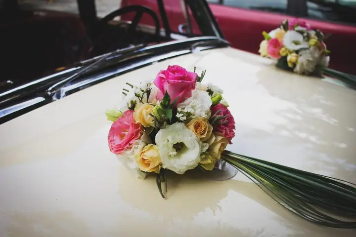 Buquê de flores sobre o capô de um carro